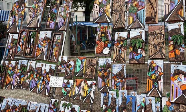 Photos of wood sculpture paintings at Feira Hippie de Ipanema